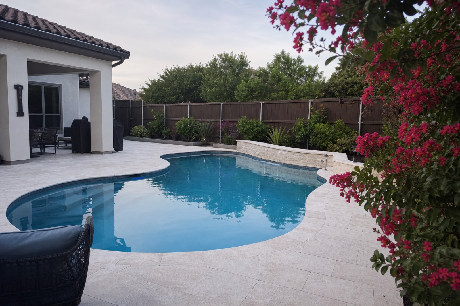A clean residential pool with deep blue water and a white limestone deck in a Mesquite backyard.